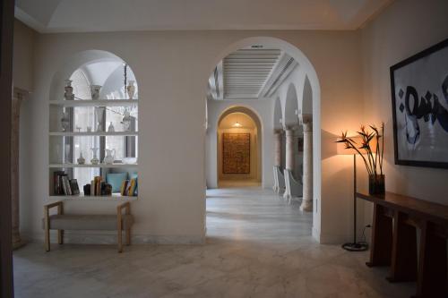 a hallway with white walls and an archway at Dar El Jeld Hotel and Spa in Tunis