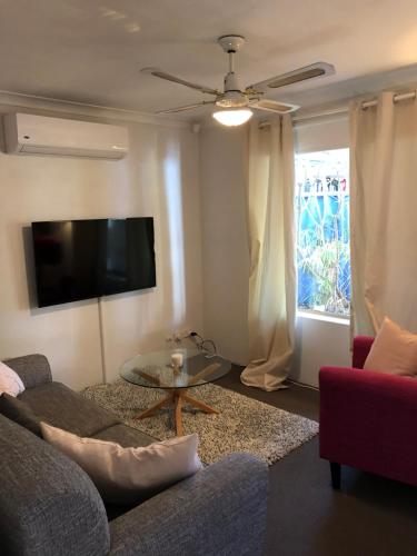 a living room with a couch and a flat screen tv at Glenelg Street in Perth