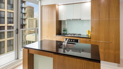 a kitchen with a sink and a large window at Oaks Adelaide Embassy Suites in Adelaide