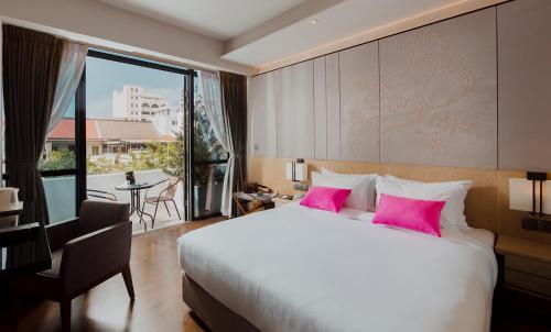 sypialnia z dużym łóżkiem z różowymi poduszkami w obiekcie Victoria Garden Hotel w mieście George Town