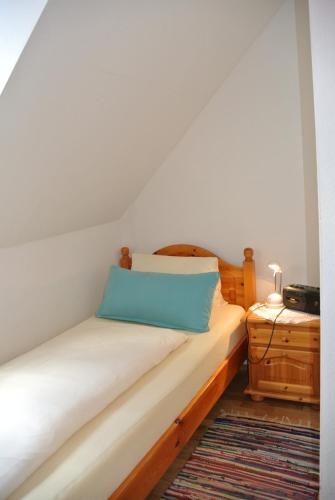 a bedroom with a bed with a blue pillow on it at Weingut Primus Südsteiermark in Spielfeld
