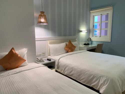 a hotel room with two beds and a window at Joy Hotel in Taitung City