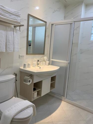 uma casa de banho com um chuveiro, um lavatório e um WC. em Joy Hotel em Taitung City