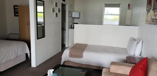 Habitación pequeña con cama y sofá en Whangaroa Lodge Motel, en Whangaroa
