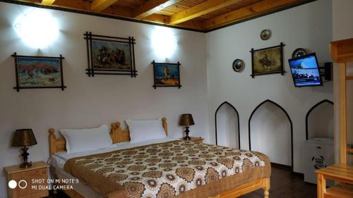 a bedroom with a bed and some pictures on the wall at Rabat Boutique in Samarkand