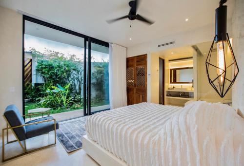 a bedroom with a white bed and a large window at Villa LaGú Masterpiece Tulum Jungle 5BR Pool & Spa in Tulum