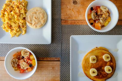 a table with plates of food and a bowl of food at Mucura Hotel & Spa in Cartagena de Indias