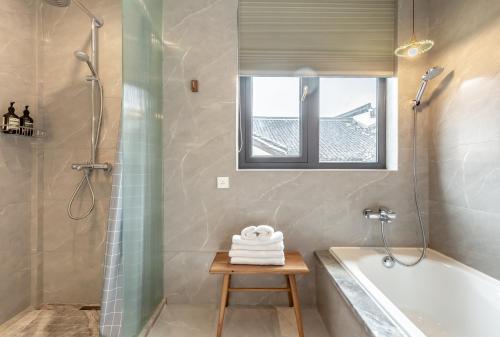 a bathroom with a tub and a shower and a sink at Cheng Zhai in Hangzhou