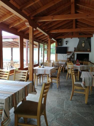a restaurant with tables and chairs and a fireplace at By the River Hotel Complex in Balkanets