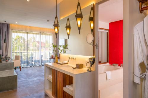 a bathroom with a sink and a bath tub at The Villa by Metta in Siem Reap