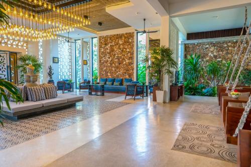 a lobby with couches and chairs and plants at The Villa by Metta in Siem Reap