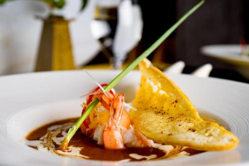 a white plate of food with shrimp and toast at The Villa by Metta in Siem Reap