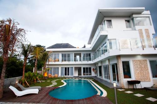 a house with a swimming pool in front of it at Vanilla Suite Jimbaran in Jimbaran