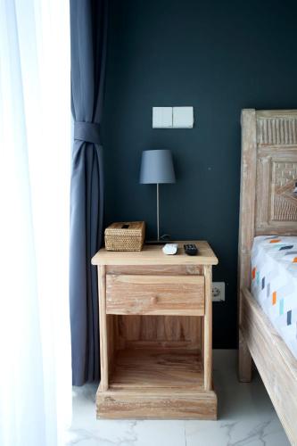 a bedroom with a bed and a table with a lamp at Vanilla Suite Jimbaran in Jimbaran