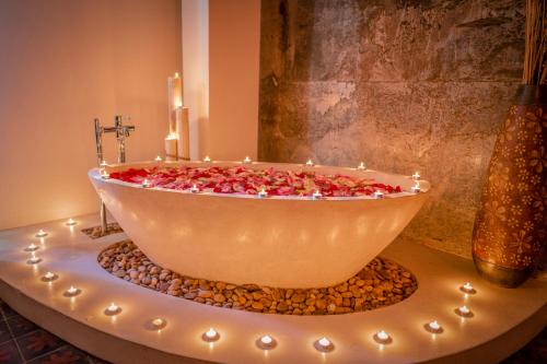a bath tub filled with candles and a candle holder at The Villa by Metta in Siem Reap