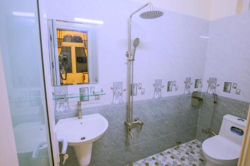 uma casa de banho com um lavatório, um chuveiro e um WC. em KHÁCH SẠN GIA THỊNH LÝ SƠN em Ly Son