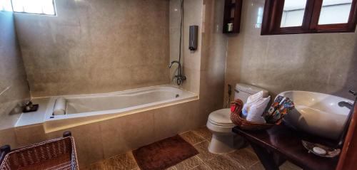 ein Badezimmer mit einer Badewanne, einem WC und einem Waschbecken in der Unterkunft Luang Prabang chanon hotel in Luang Prabang