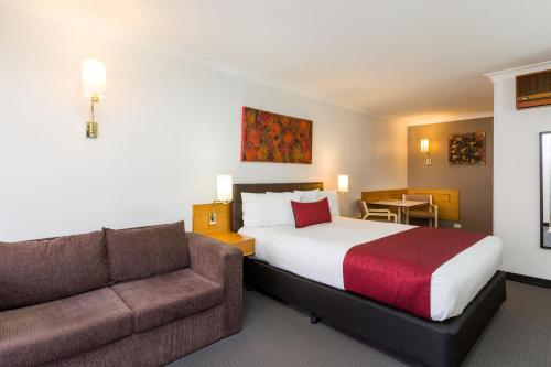 a hotel room with a bed and a couch at Hermitage Motor Inn in Wangaratta