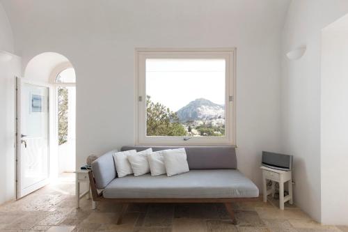 a couch sitting in a room with a window at Casa Capaianca in Capri
