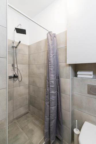 a shower with a shower curtain in a bathroom at Madach Apartment in Budapest