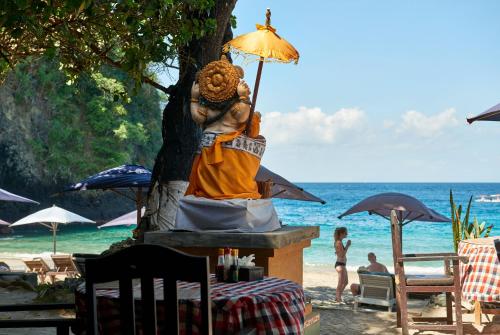 a statue of a person holding an umbrella on the beach at Jasri Bay Hideaway in Jasri