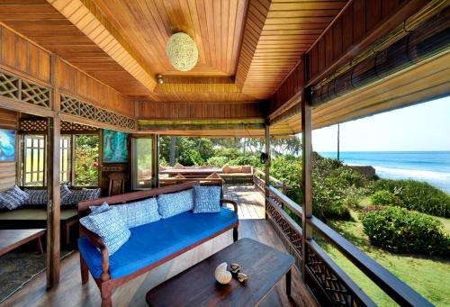 a porch of a house with a couch and a table at Jasri Bay Hideaway in Jasri