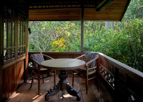 a table and chairs on the porch of a house at Jasri Bay Hideaway in Jasri