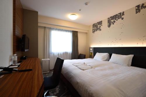 a hotel room with a large bed and a desk at Kichijoji Tokyu REI Hotel in Musashino