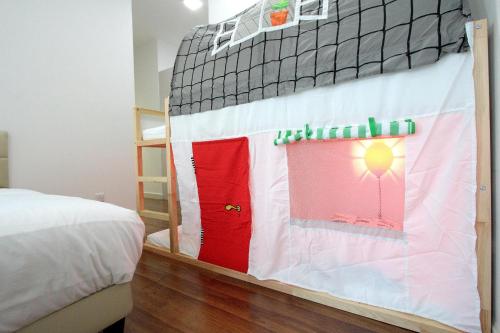 a bedroom with a bunk bed with red and white sheets at Afiniti Residensi Legoland Medini in Nusajaya