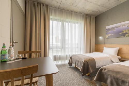 a hotel room with two beds and a table at Air Hotel in Karmėlava