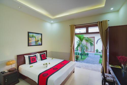 Un dormitorio con una cama grande y una ventana en Herbal Tea Homestay, en Hoi An