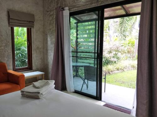 a bedroom with a bed and a window with a view at The Leaf Bankrut in Bang Saphan