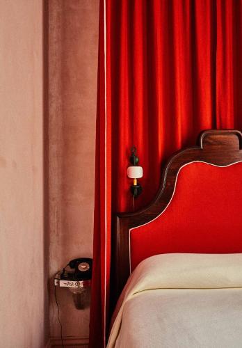 a bedroom with a red curtain and a bed at Hotel Peter and Paul, an Ash Hotel in New Orleans