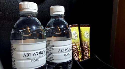 two bottles of water sitting next to some snacks at Artworks Hotel Ipoh in Ipoh