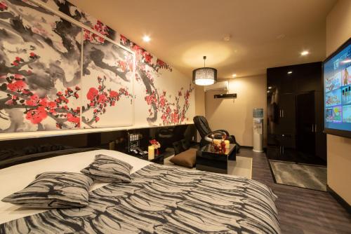 a bedroom with a large bed and a tv at Hotel Waraku Shibukawa in Shibukawa