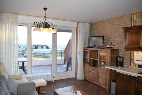 a kitchen and living room with a view of a balcony at Haus am Deich Wohnung 12 in Dahme