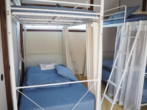 a couple of bunk beds in a room at Guesthouse ＆ Beach Cafe Fuego in Hyuga