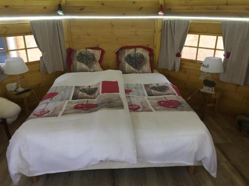 um quarto com uma cama com lençóis brancos em Alaguyauder le KOTA em Châtillon-sur-Broué