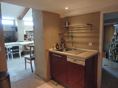 a kitchen with a sink and a dining room at Le Jas de Péguier in Châteauneuf-Val-Saint-Donat