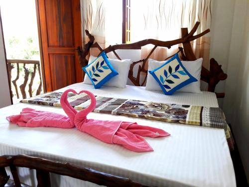 two pink towels sitting on top of a bed at Green Paradise in Ella