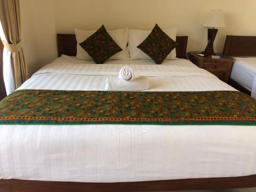 a white bed with a towel on top of it at Sari Nusa Inn in Nusa Lembongan