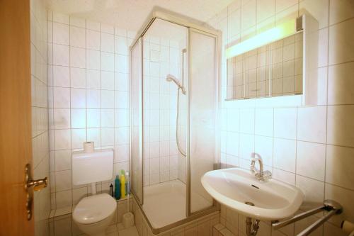 a bathroom with a shower and a sink and a toilet at Gaestehaus-Achtern-Diek-Wohnung-6 in Süderhöft