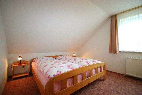 a bedroom with a bed and a window at Gaestehaus-Achtern-Diek-Wohnung-11 in Süderhöft