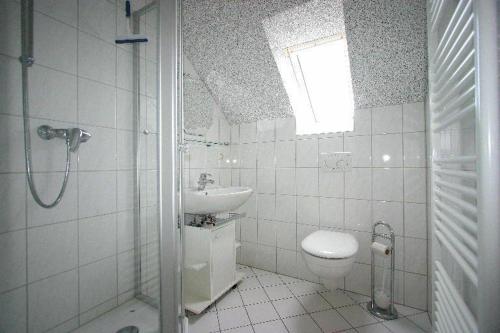 a bathroom with a sink and a toilet and a shower at Gaestehaus-Achtern-Diek-Wohnung-11 in Süderhöft