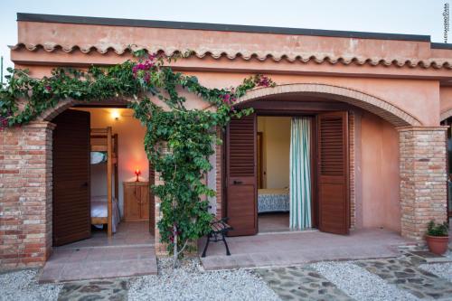 a house with an archway and a room with a bed at Residenza Su Prelau in Gonnesa