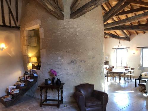 a living room with a chair and a stone wall at La Tour Barbacane in Alan