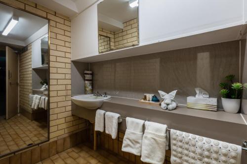 a bathroom with a sink and a mirror and towels at Sails Geraldton Accommodation in Geraldton