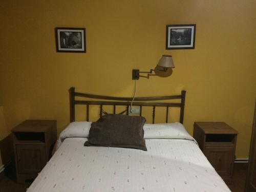 a bedroom with a white bed with two night stands at LA ANTIGUA TAHONA in Navaconcejo