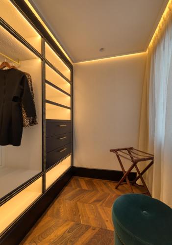 a walk in closet with a mirror and a chair at BLESS Hotel Madrid - The Leading Hotels of the World in Madrid