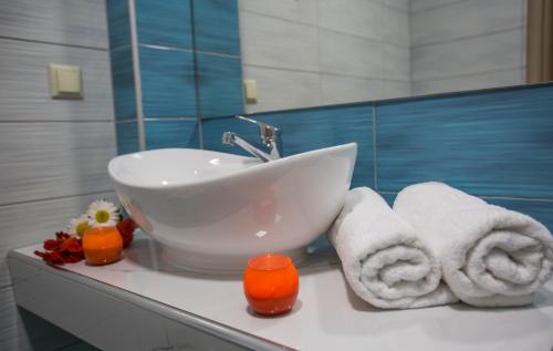 a bathroom with a sink and towels on a counter at Kozanos Hotel & Suites in Amoudi